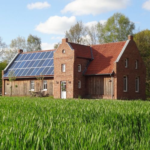 Foto: Haus und Hof, altes Backsteinhaus mit riesiger Solaranlage auf dem Dach